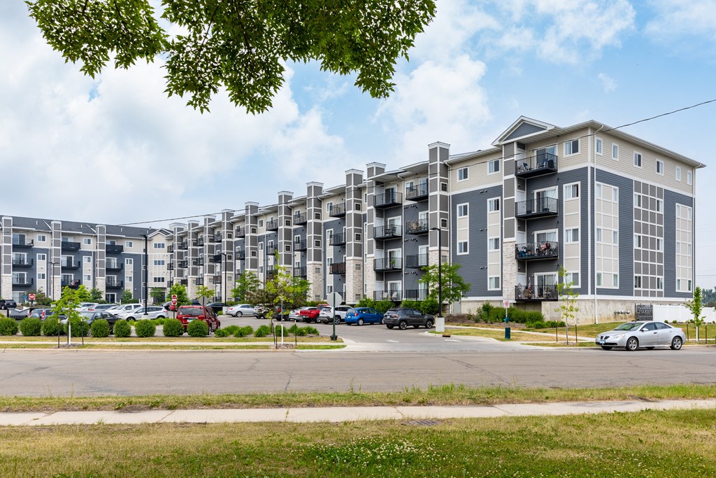a large apartment complex with cars parked in front of it