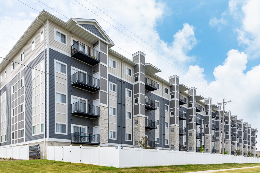 a large apartment building with balconies and a blue sky in the background