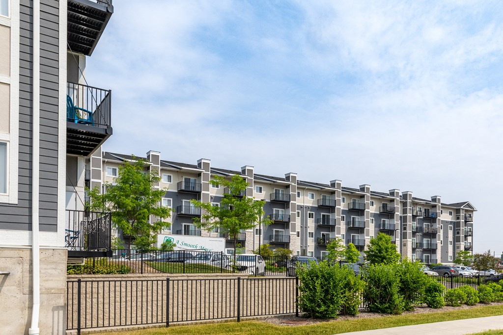 a large apartment building with balconies and trees in front of it