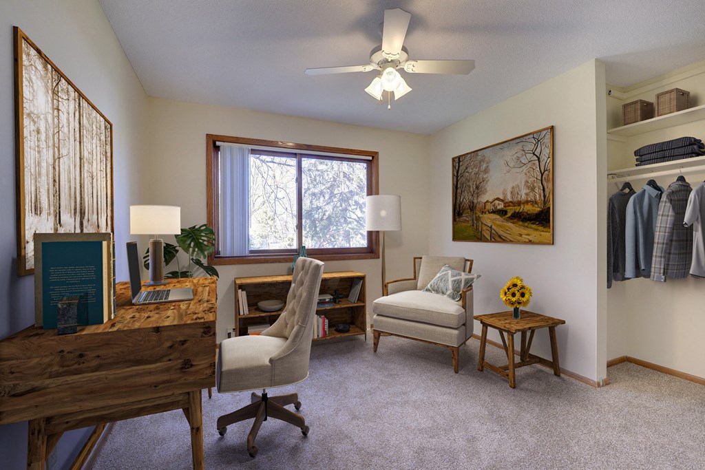 the living room of a home with two chairs and a desk