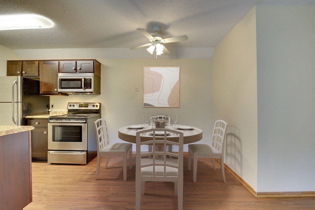 a kitchen and dining room with a table and chairs and a ceiling fan