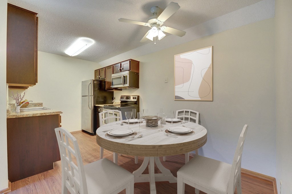 a kitchen and dining room with a table and chairs and a ceiling fan