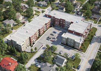 an aerial view of a brick apartment complex with cars parked in front of it