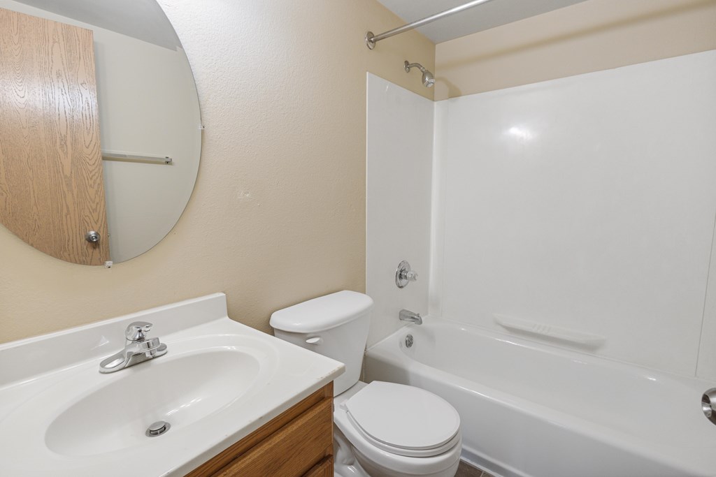 A white toilet sits next to a sink in a bathroom at Ames Lake Neighborhood Apartments, Minnesota, 55106