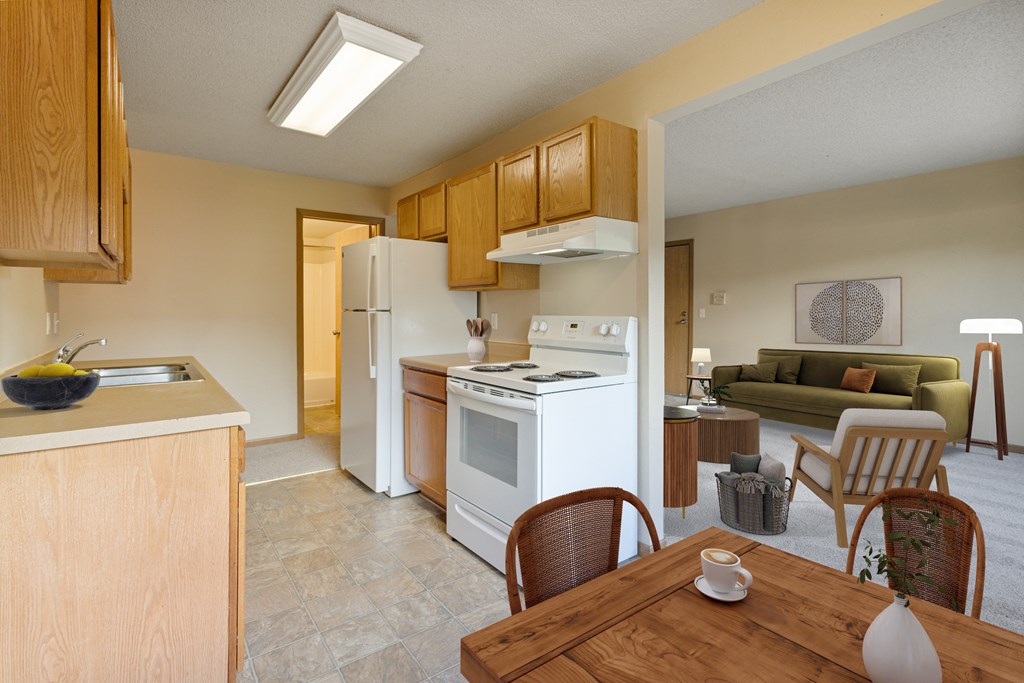 A kitchen with a table and chairs in the foreground and a couch in the background.