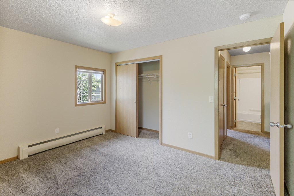 A room with a carpeted floor and a window at Ames Lake Neighborhood Apartments, Minnesota, 55106
