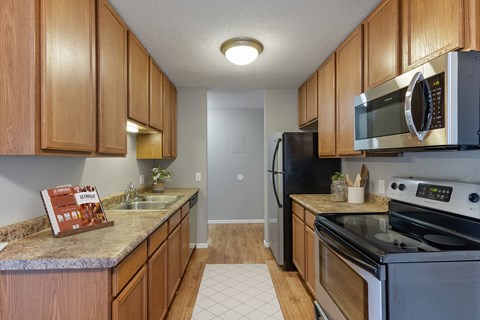 A kitchen with wooden cabinets and a granite counter top.