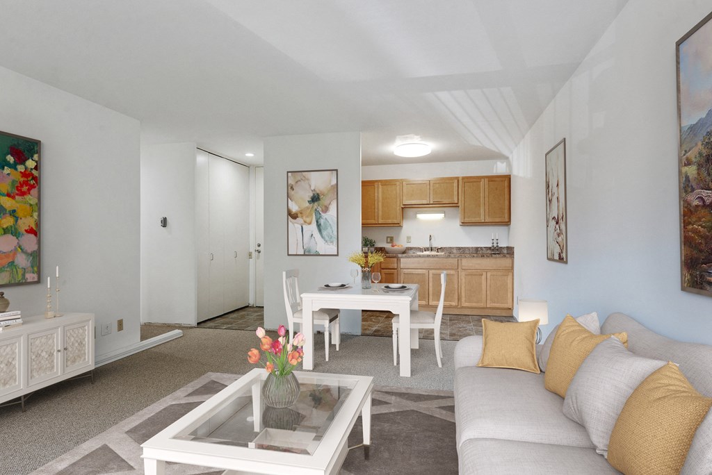 a living room with a couch and a table and a kitchen at Humboldt Senior 55+ Apartments, Saint Paul