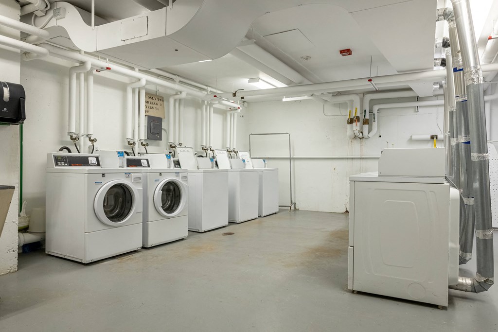 a row of washing machines and dryers in a laundry room at Humboldt Senior 55+ Apartments, Minnesota, 55107