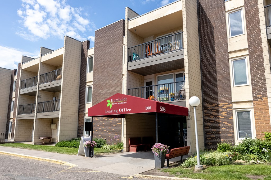 an apartment building with a red awning in front of it at Humboldt Senior 55+ Apartments, Minnesota