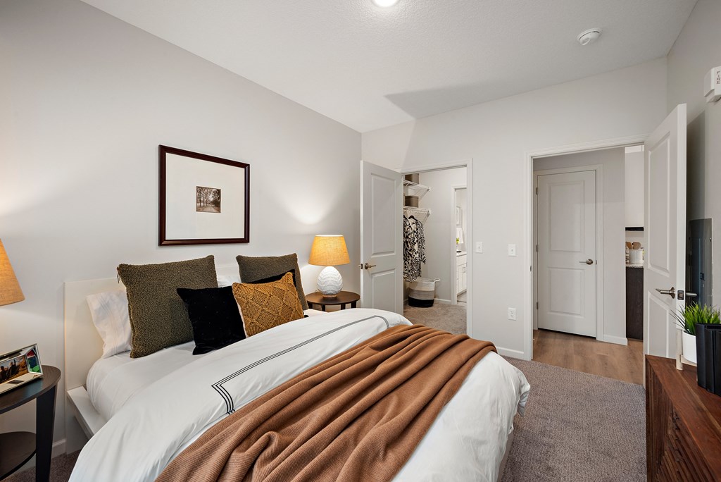 a bedroom with a large bed and a bathroom at The Landing at Amber Fields Apartments, Rosemount, 55068