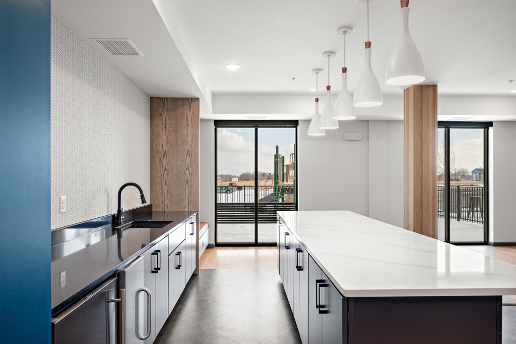 A modern kitchen with a large island and stainless steel appliances. at The Landing at Amber Fields Apartments, Minnesota, 55068