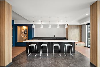 A modern kitchen with a bar stool at The Landing at Amber Fields Apartments, Rosemount, MN