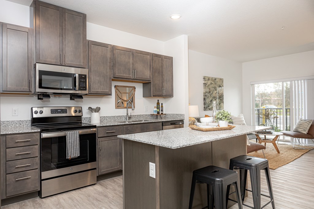 an open kitchen with stainless steel appliances and granite counter tops