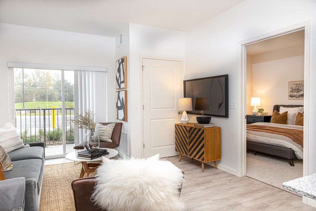 a living room with a couch and a tv and a bedroom with a bed