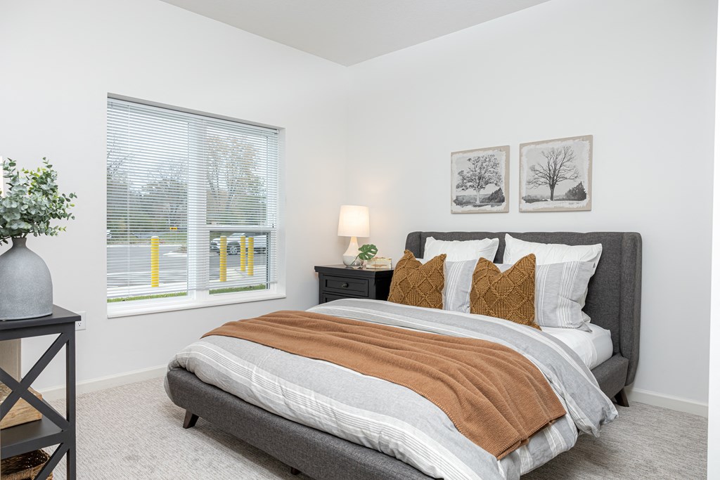 a bedroom with a bed and two windows