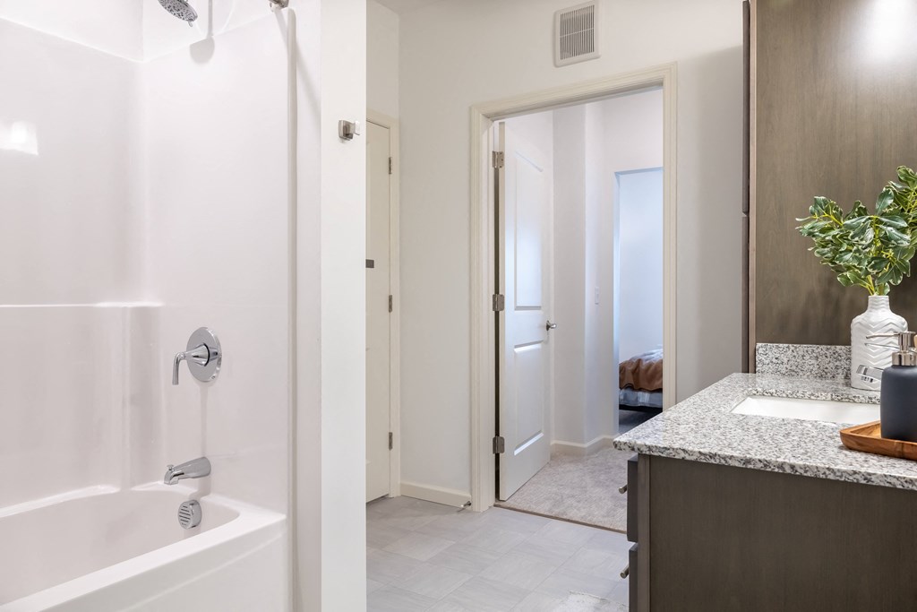 a bathroom with a shower and a sink and a mirror