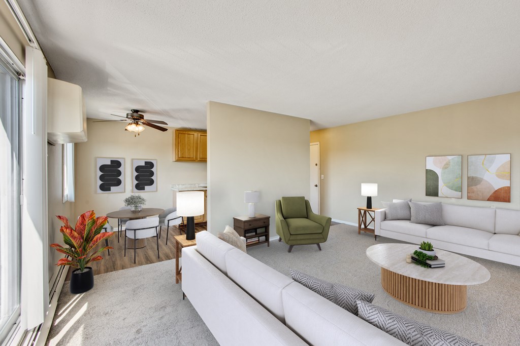 A living room with a white couch, a green chair, and a wooden coffee table.