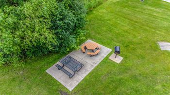 a backyard patio with a table and chairs and a fire pit