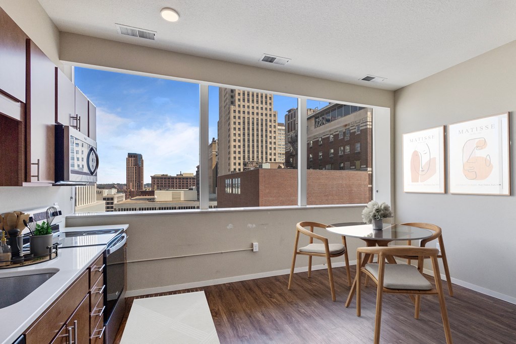 a kitchen with wooden cabinets and a view of the city at Press House Apartments, St Paul, MN