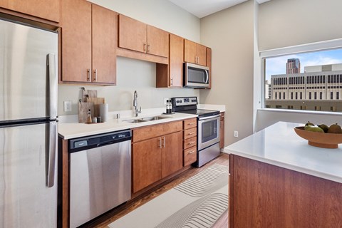 a kitchen with wooden cabinets and stainless steel appliances and a window