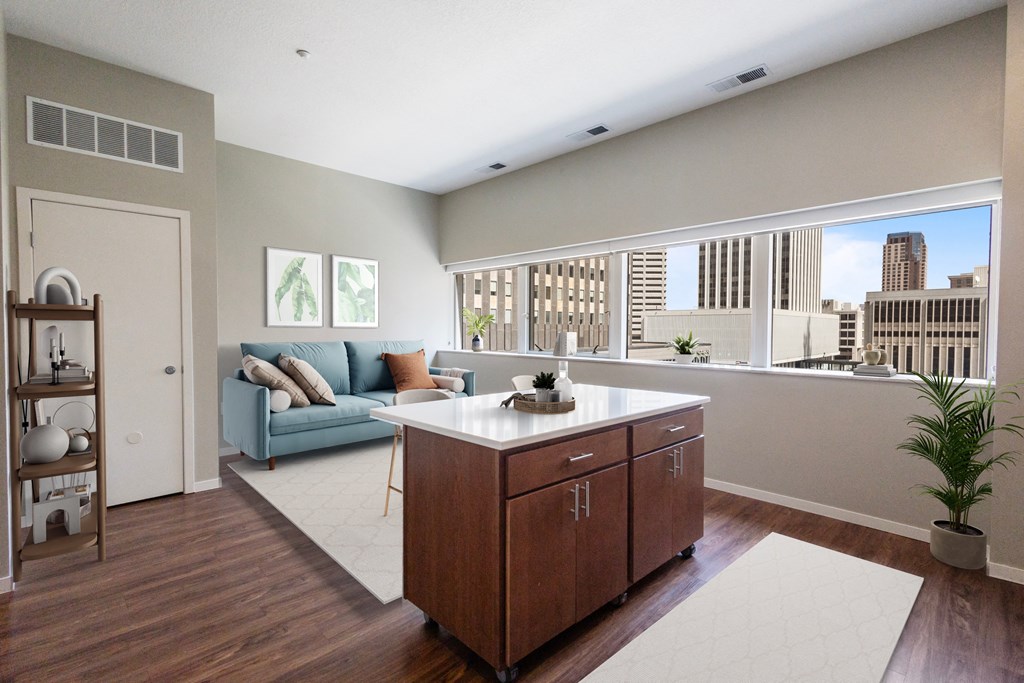 a living room with a kitchen and a large window at Press House Apartments, St Paul, MN, 55101