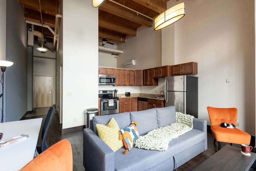 a living room with a couch and a kitchen in the background