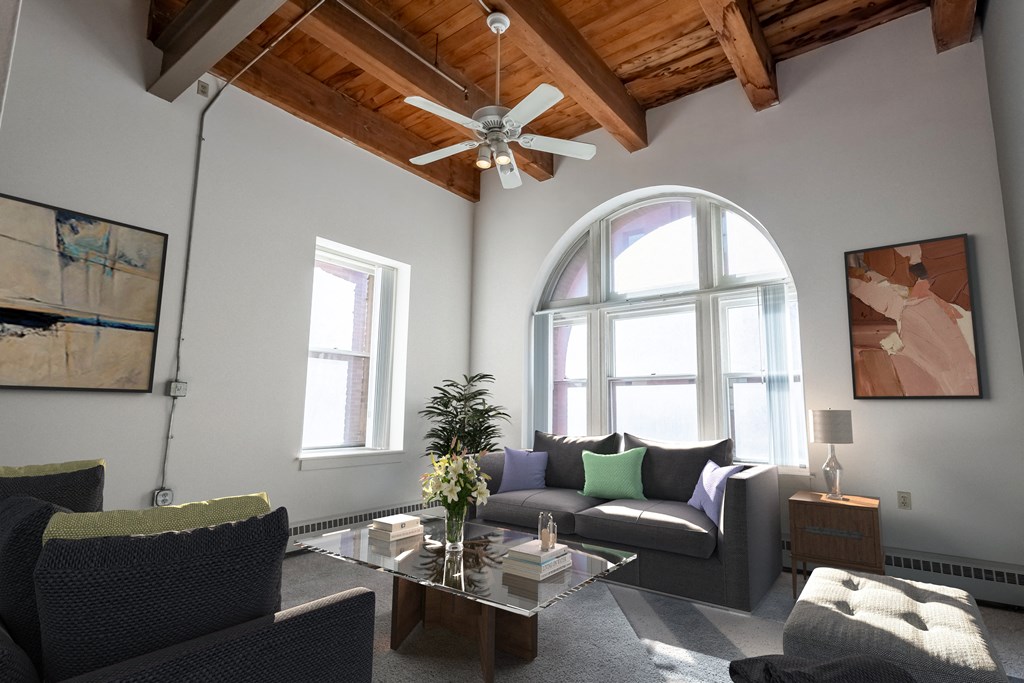 a living room with a ceiling fan and a large window