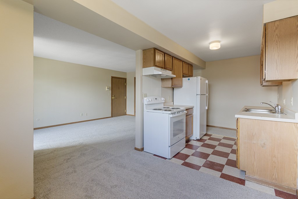 A kitchen with a white fridge and a checkered floor at Ames Lake Neighborhood Apartments, Minnesota, 55106