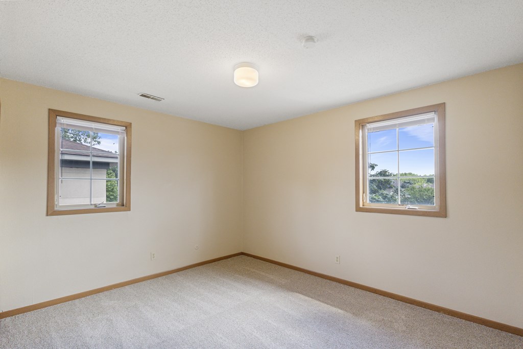 A room with two windows and carpeted flooring at Ames Lake Neighborhood Apartments, Minnesota