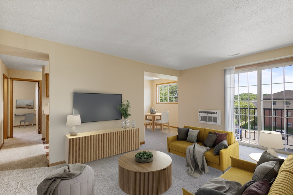 A living room with a yellow couch and a flat screen TV mounted on the wall.