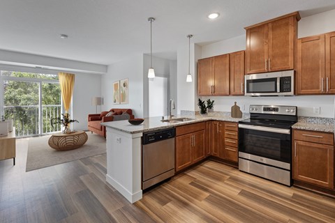 an open kitchen and living room with wooden floors and wooden cabinets