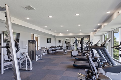 a gym with various cardio machines and weights
