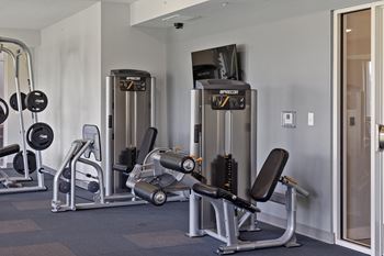 a fitness room with cardio machines and other exercise equipment