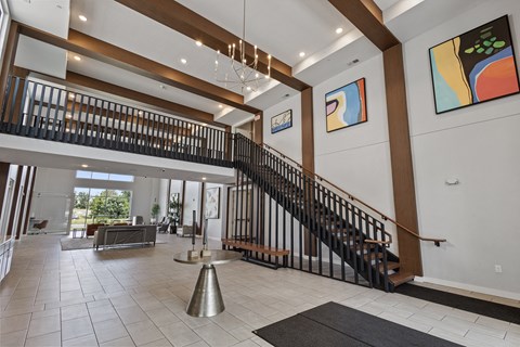 the entryway of a house with a staircase and a table in the center