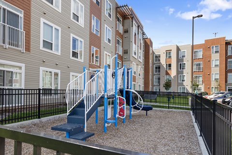 a blue playground in front of an apartment building