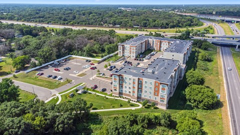 an aerial view of an apartment building next to a highway