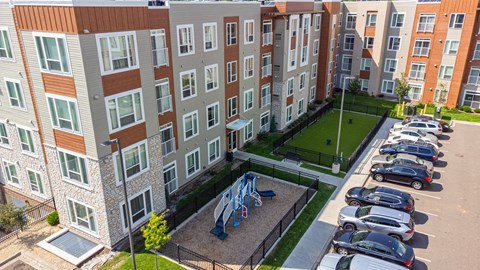 an aerial view of an apartment building with cars parked in a parking lot