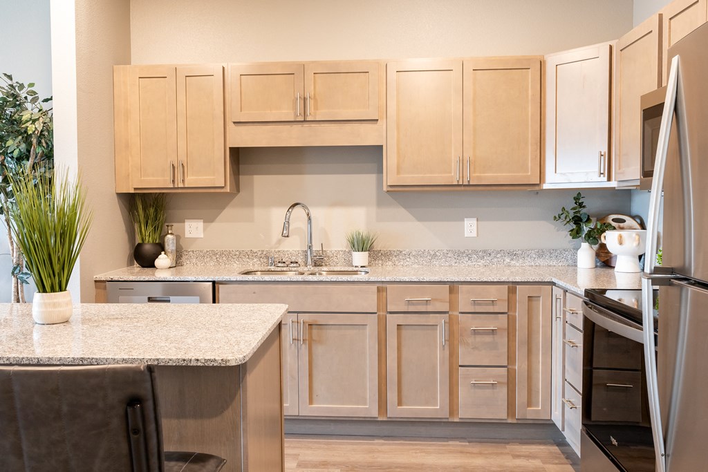 a kitchen with wooden cabinets and granite counter tops at Technology Park Apartments, Rochester