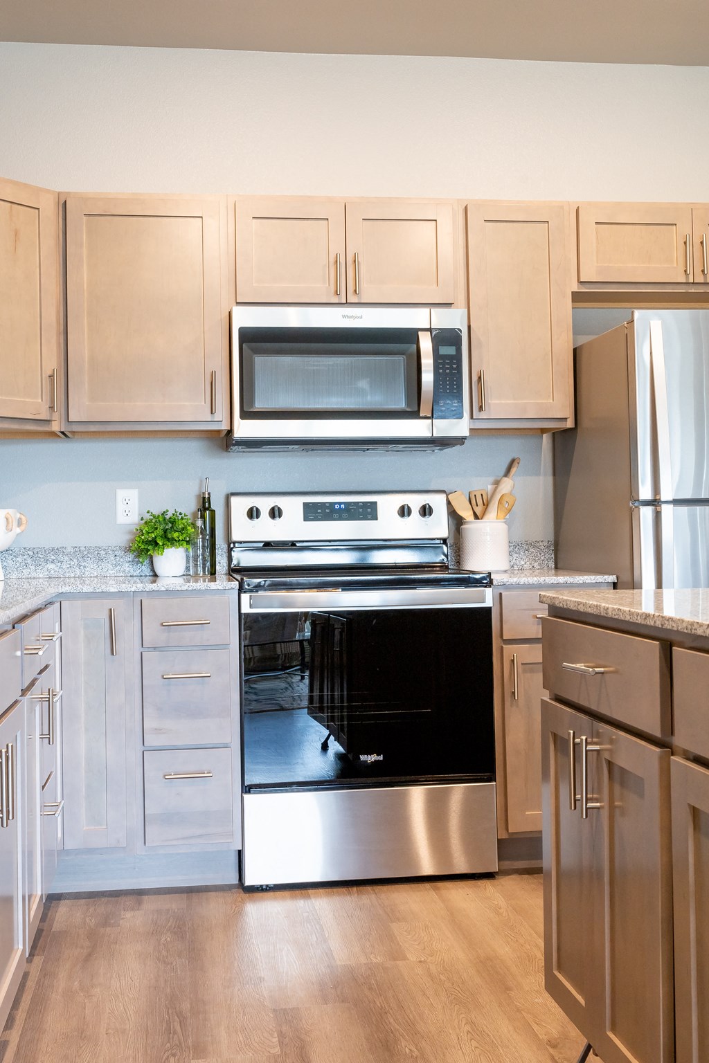 a modern kitchen with stainless steel appliances and white cabinets at Technology Park Apartments, Rochester, Minnesota