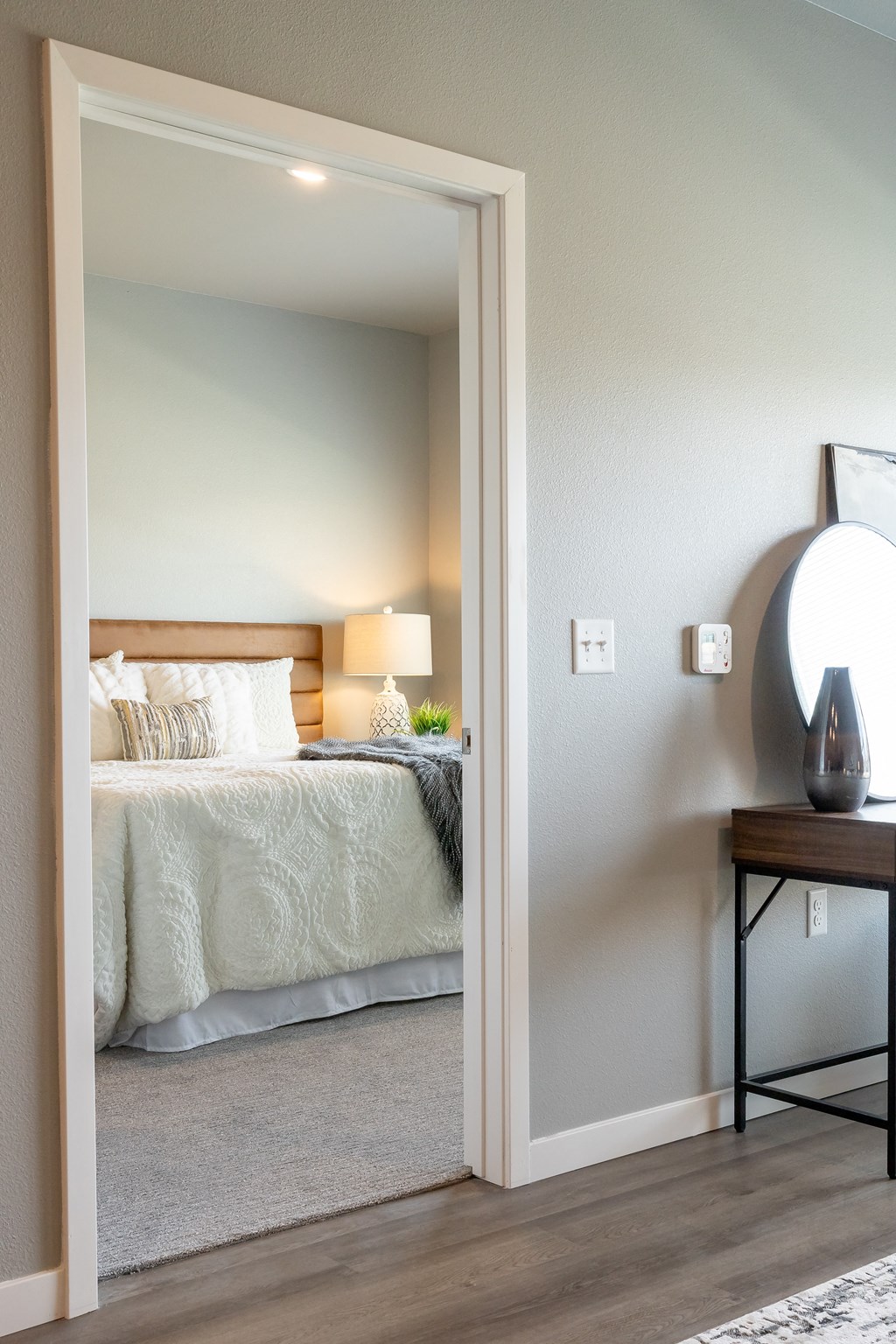 a bedroom with a bed and a nightstand and a mirror at Technology Park Apartments, Rochester