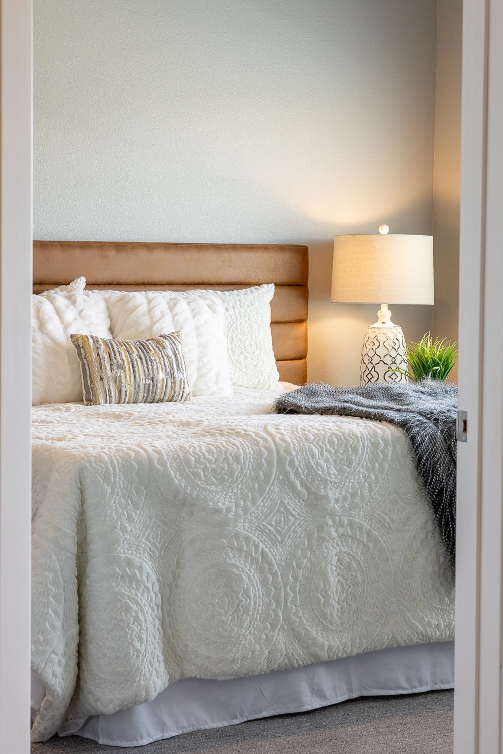 a bedroom with a bed and pillows and a lamp at Technology Park Apartments, Minnesota, 55901