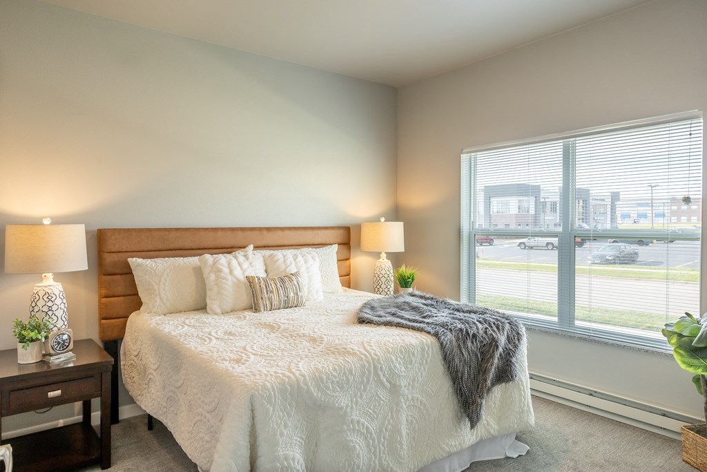 a bedroom with a bed and a large window at Technology Park Apartments, Rochester, MN, 55901