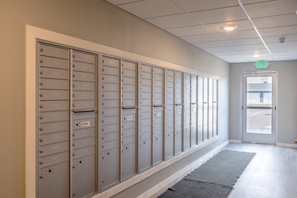 a row of lockers in a hallway with an exit door at Technology Park Apartments, Rochester, Minnesota