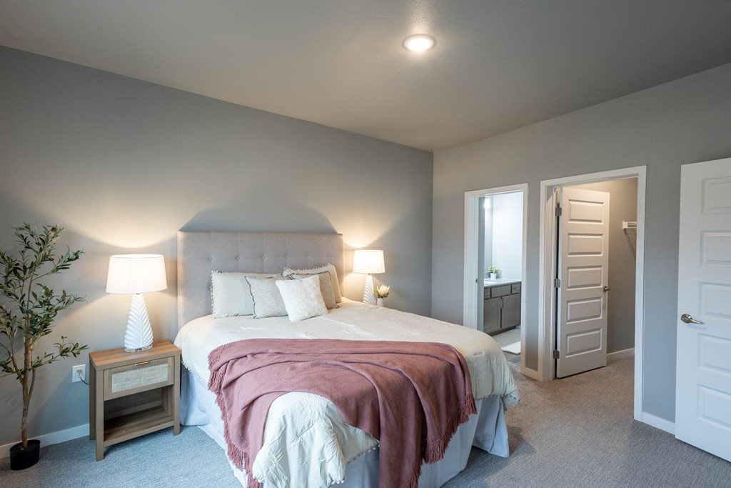 a bedroom with a large bed and a door to a bathroom at Technology Park Apartments, Rochester, Minnesota