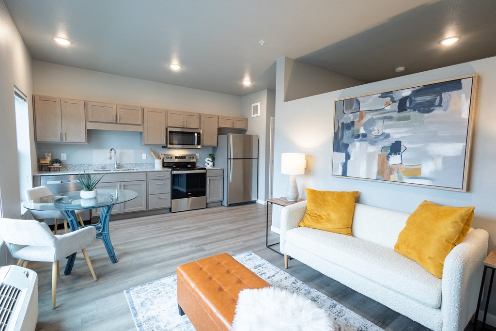 a living room with a couch and a table and a kitchen at Technology Park Apartments, Minnesota