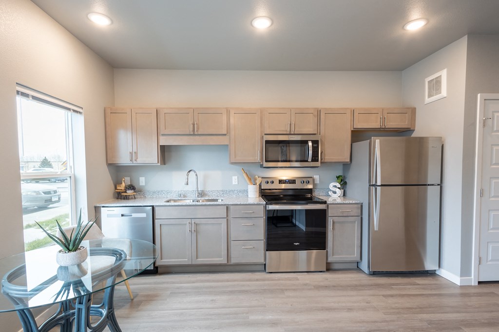 a kitchen with stainless steel appliances and white cabinets at Technology Park Apartments, Rochester, Minnesota