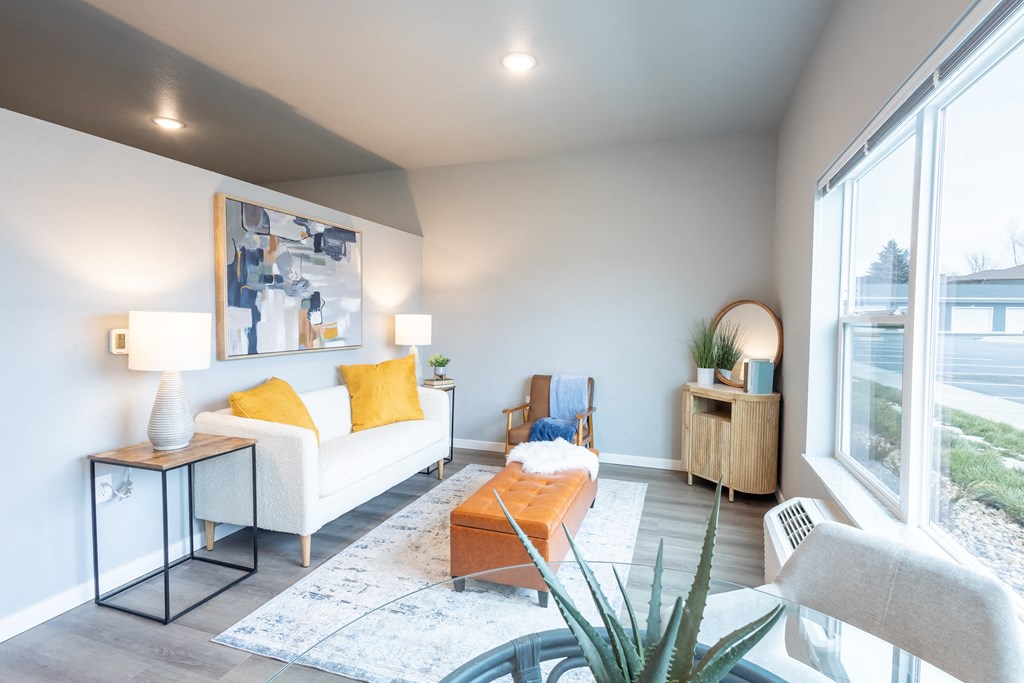 a living room with a couch and a coffee table and a large window at Technology Park Apartments, Rochester, Minnesota