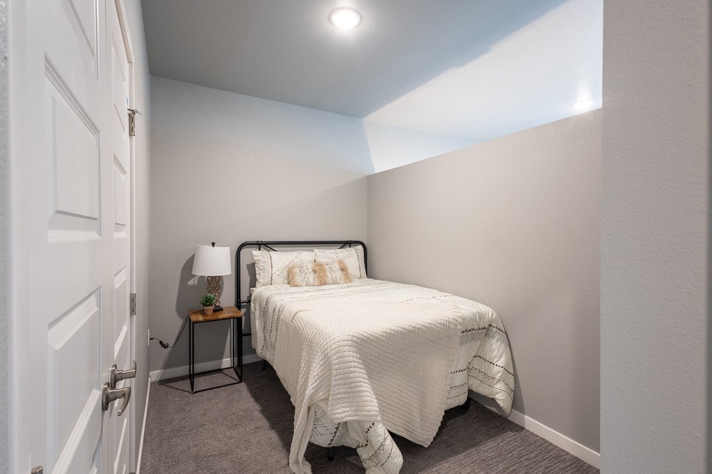 a bedroom with a small bed and a white closet at Technology Park Apartments, Minnesota, 55901