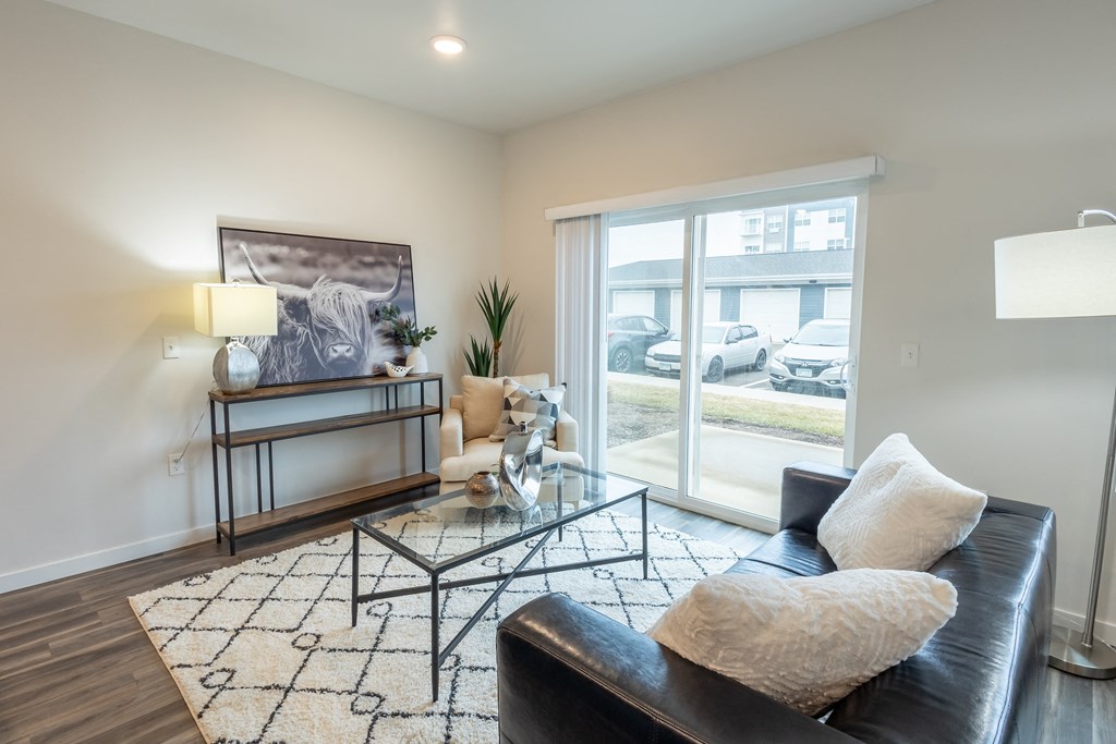 a living room with a black leather couch and a glass coffee table at Technology Park Apartments, Rochester, 55901
